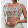 Beaded embellishments catch the light on this stunning pastel green lehenga choli set as it's sty...