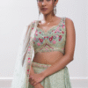 Closet view of the pastel green lehenga choli set with dupatta, showcasing its vibrant color and ...
