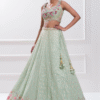 Close-up of pastel green lehenga choli's delicate floral pattern and shimmering fabric texture.:{...