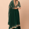 A stylish pose highlights the intricate embroidery on the back panel of the green mehendi lehenga...